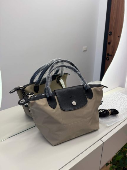 Çanta Longchamp Le Pliage, beige tote with black leather accents.