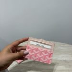 Pink Goyard unisex cardholder on marble table.