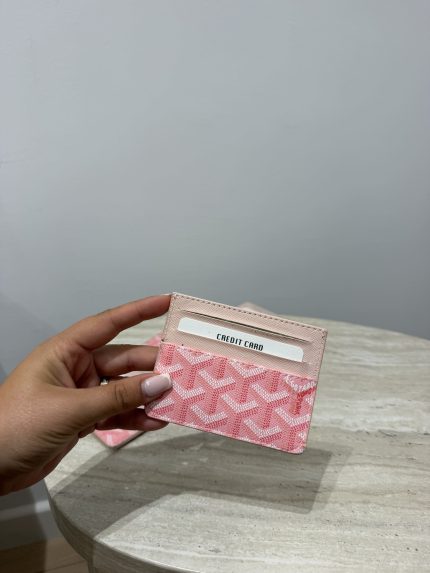 Pink Goyard unisex cardholder on marble table.