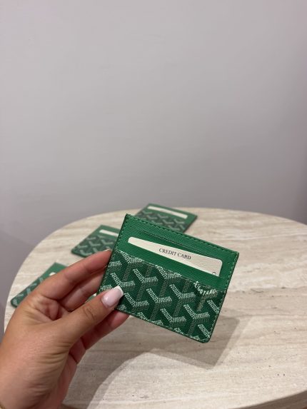 Green Goyard unisex cardholder on marble table.
