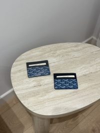Goyard unisex cardholders on a marble table, elegant and functional design.