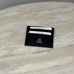 Calvin Klein black cardholder on marble surface, elegant and practical design.
