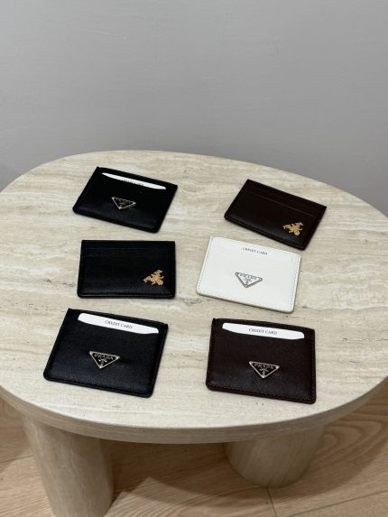 Prada Saffiano card holders in black, white, and brown on table.