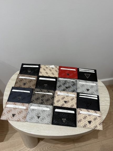 Guess unisex card holders displayed on a table, various colors.