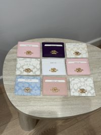 Colorful Coach cardholders displayed on a table.