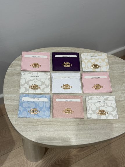 Colorful Coach cardholders displayed on a table.