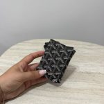 Goyard card holder with mechanism on marble table.