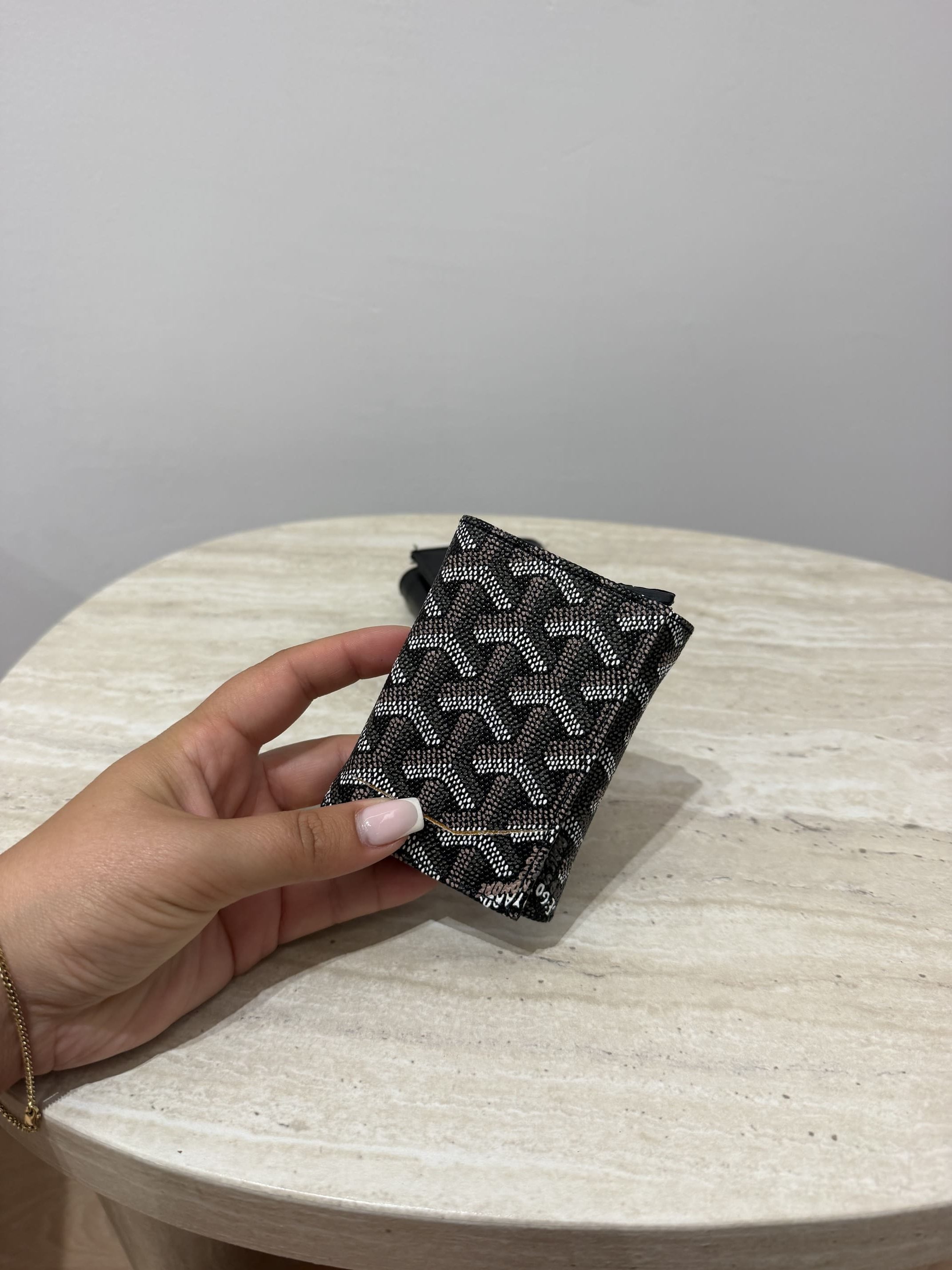 ds-portofola-112-1 Goyard card holder with mechanism on marble table.