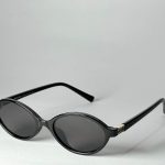 Miu Miu women's black round sunglasses with gold accents.