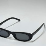 Women's Saint Laurent black sunglasses on white background.