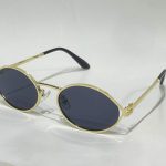 Miu Miu gold metal sunglasses with dark lenses.