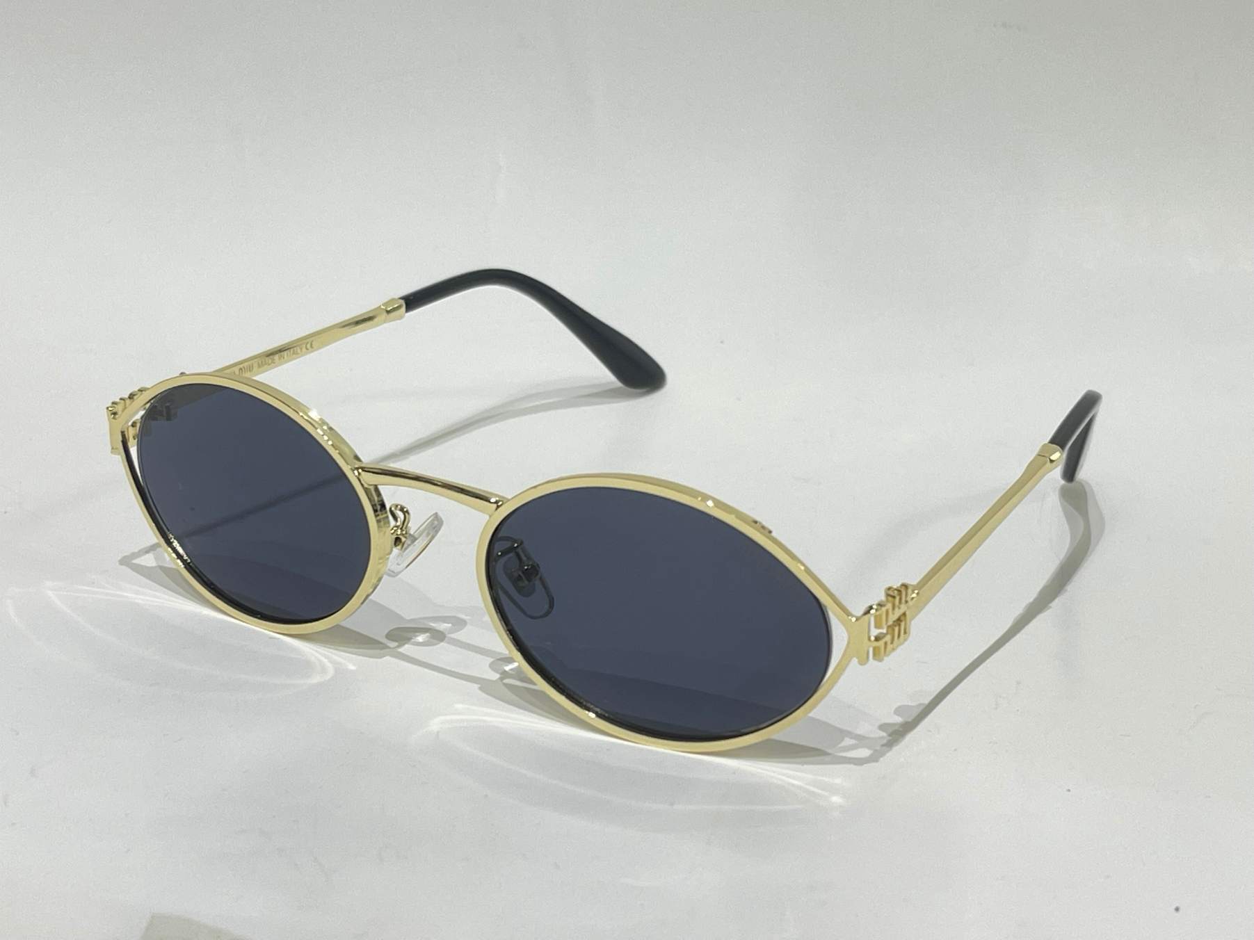 ds-syze-335-kryesore Miu Miu gold metal sunglasses with dark lenses.