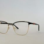 Elegant black and gold eyeglasses with clear lenses.