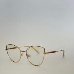 Skelete Optike Daisy Store stylish gold eyeglasses on white background.