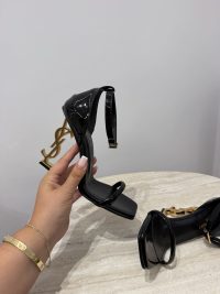Black YSL Opyum sandals with gold heel logo on display.