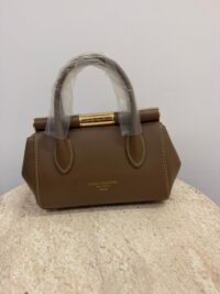 Dolce & Gabbana brown handbag with gold frame on marble surface.