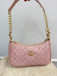 Pink Coach handbag with gold chain handle and logo.