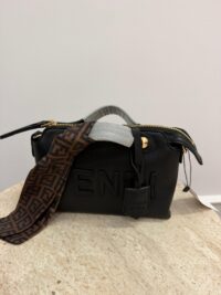 Black Fendi By The Way bag with patterned strap on table.