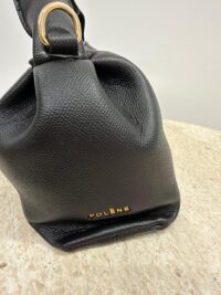 Çantë dore lëkure Polène, elegant black leather handbag with gold accents.