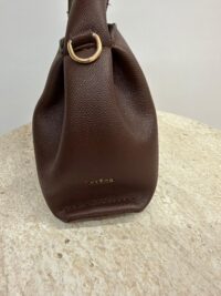 Brown Polène leather handbag with gold ring detail on table.