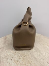Brown leather Polène handbag with gold accents on table.