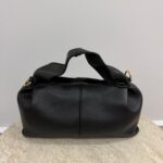 Black Polène leather handbag on beige surface.