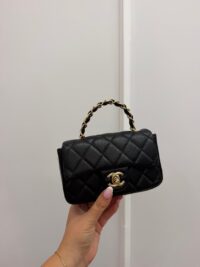 Chanel Mini Flap bag with gold chain handle, black quilted leather.