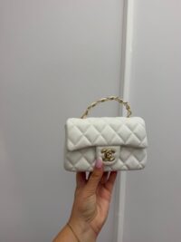 Chanel Mini Flap bag with gold chain handle, white quilted leather.