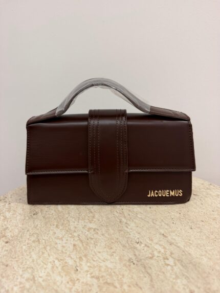 Brown Jacquemus Le Bambino Long handbag on textured surface.