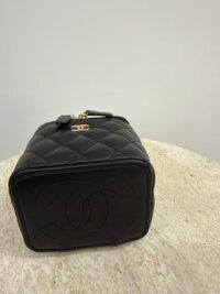 Chanel Vanity Mini black quilted elegant handbag on table.