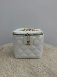 White Chanel Vanity Mini bag with gold chain and quilted design.