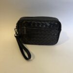 Black woven leather handbag with wrist strap and zipper pocket.