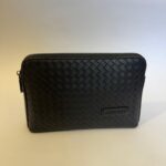 Bottega Veneta black clutch, elegant woven leather design.