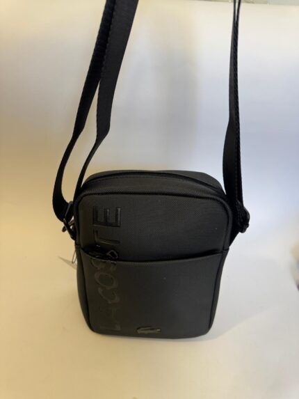 Black Lacoste men's bag with shoulder strap and logo.