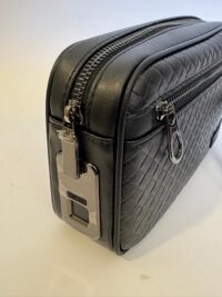 Elegant black quilted handbag with secure lock and zipper detail.